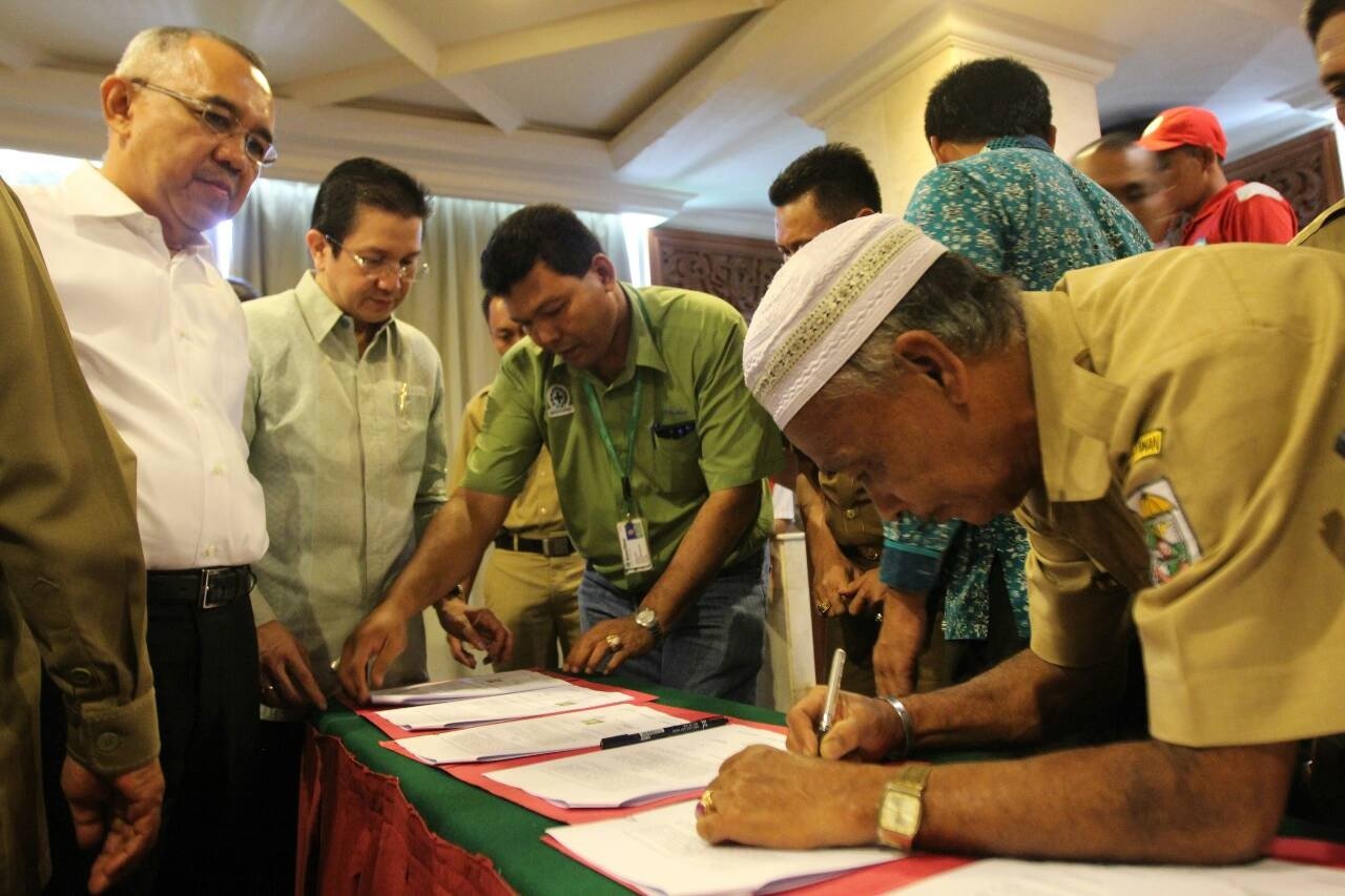 Yunus, Sering village chief, signs a cooperation agreement alongside 8 other villages, reaffirming their participation in the Fire Free Village Programme, witnessed by Riau Interim Governor Arsyadjuliandi Rachman and APRIL MD, Tony Wenas